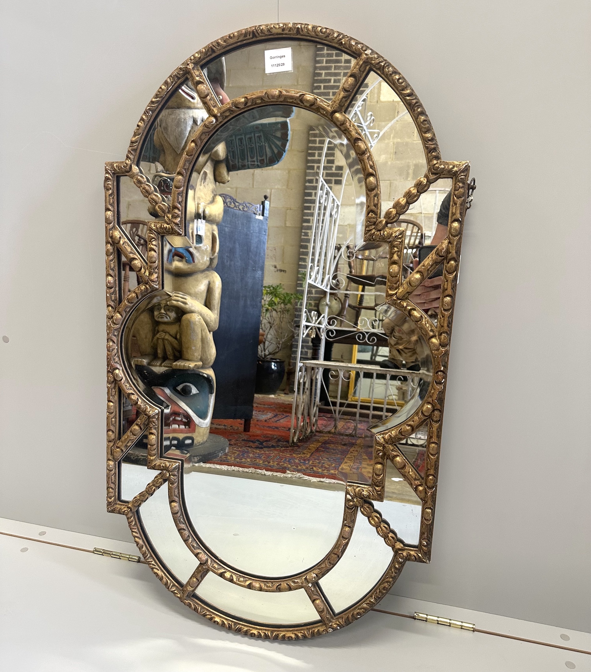 A Victorian carved giltwood and gesso shaped oval mirror, with marginal plates, width 57cm, height 100cm